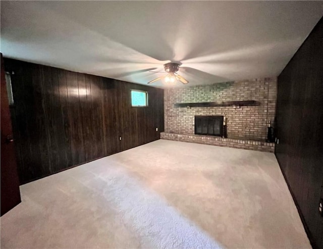 590 N Kings Creek Rd, Pa, PA 15021 - unfurnished living room with carpet floors, a brick fireplace, wood walls, and a ceiling fan