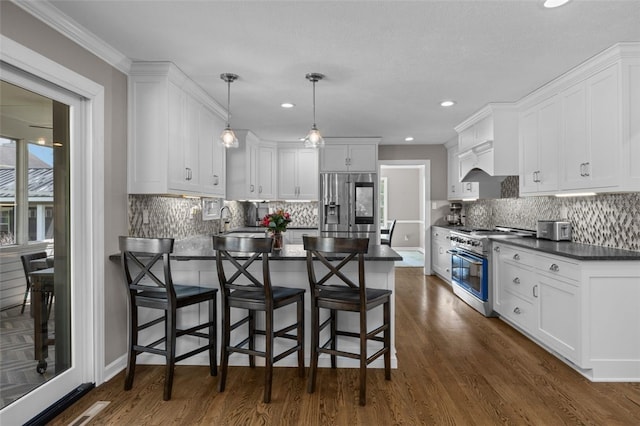 809 Timber Trl, Collier Twp, PA 15071 - kitchen featuring stainless steel appliances, dark countertops, a peninsula, dark wood-style flooring, and recessed lighting