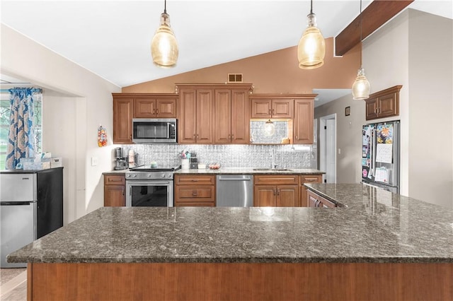 507 Moss Ln, Pymatuning Twp, PA 16125 - kitchen featuring appliances with stainless steel finishes, vaulted ceiling, a sink, backsplash, and brown cabinets