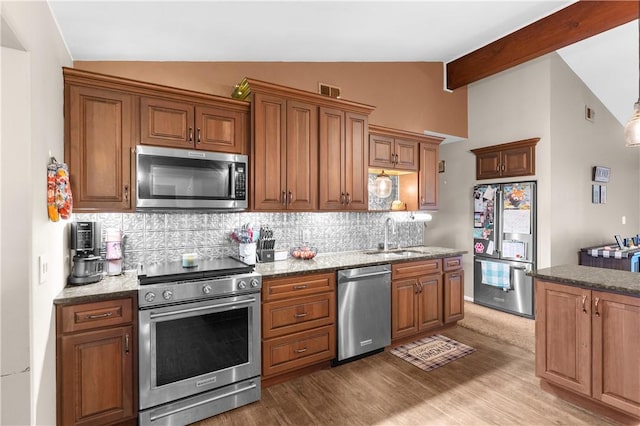 507 Moss Ln, Pymatuning Twp, PA 16125 - kitchen featuring stainless steel appliances, a sink, tasteful backsplash, wood finished floors, and brown cabinetry