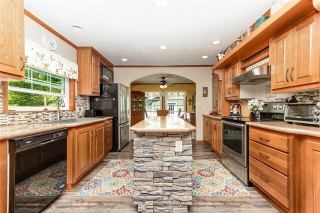 214 Fullingmill Rd, Jefferson Twp Mer, PA 16137 - kitchen featuring appliances with stainless steel finishes, exhaust hood, arched walkways, light wood-type flooring, and tasteful backsplash