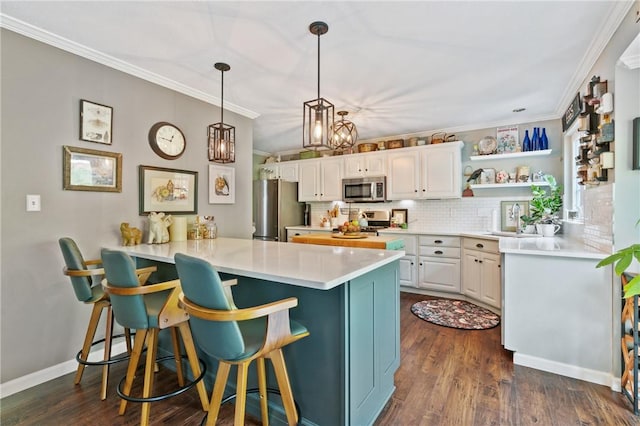 675 Village Green Blvd E, Adams Twp, PA 16046 - kitchen with appliances with stainless steel finishes, a peninsula, a kitchen bar, a sink, and ornamental molding