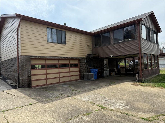 3025 Wallace St, Lower Burrell, PA 15068 - view of front of home featuring brick siding, an attached garage, concrete driveway, and central AC unit