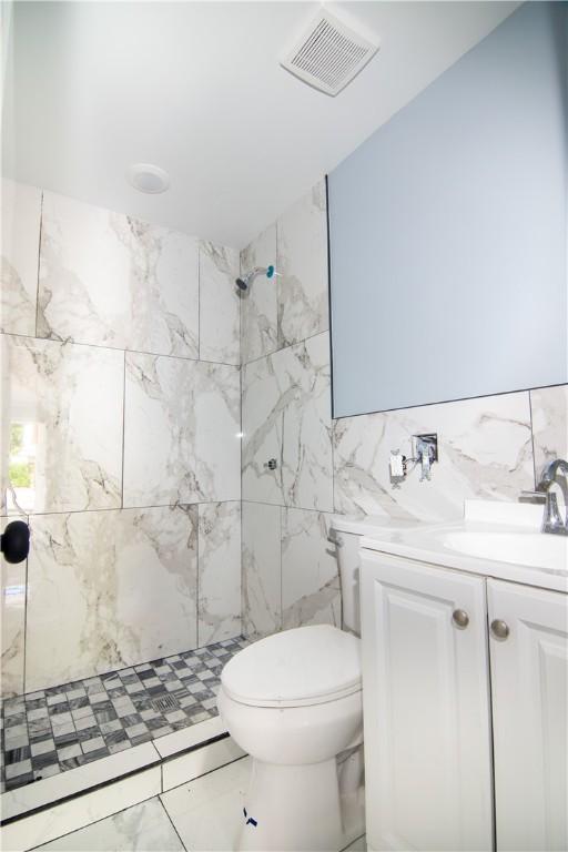 624 Wylie Ave, Jeannette, PA 15644 - bathroom with tile walls, a marble finish shower, toilet, vanity, and marble finish floors
