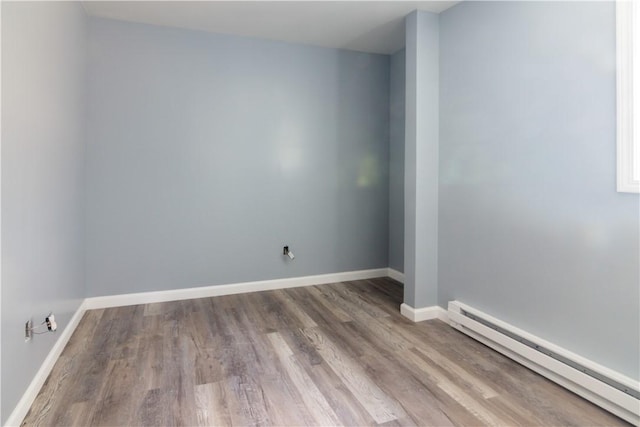 624 Wylie Ave, Jeannette, PA 15644 - empty room featuring a baseboard heating unit, wood finished floors, and baseboards