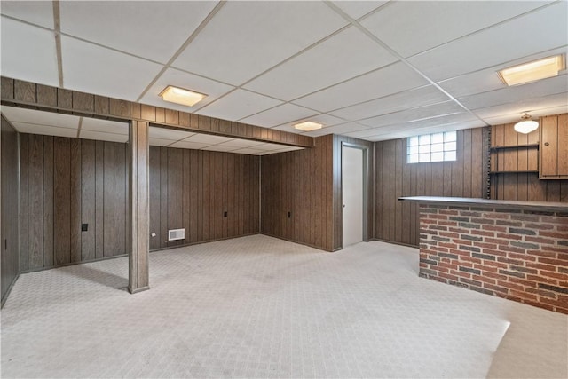 124 Wyndfield Dr, East Huntingdon, PA 15666 - basement with carpet flooring, wood walls, a paneled ceiling, and a bar