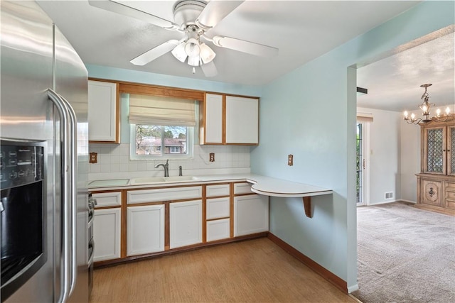 124 Wyndfield Dr, East Huntingdon, PA 15666 - kitchen featuring stainless steel fridge, a sink, light countertops, decorative backsplash, and a chandelier