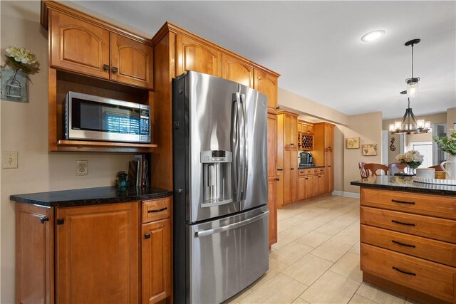 1299 Oakridge Rd, South Fayette, PA 15057 - kitchen with appliances with stainless steel finishes, a chandelier, brown cabinets, dark stone counters, and light tile patterned floors