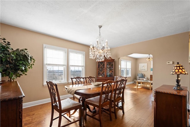 1299 Oakridge Rd, South Fayette, PA 15057 - dining room with a chandelier, wood finished floors, arched walkways, and a textured ceiling