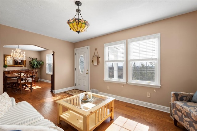 1299 Oakridge Rd, South Fayette, PA 15057 - living area with arched walkways, wood-type flooring, baseboards, and a chandelier