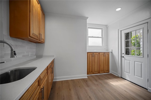 815 W Main St, Carnegie, PA 15106 - kitchen featuring a sink, brown cabinets, light wood finished floors, decorative backsplash, and light countertops