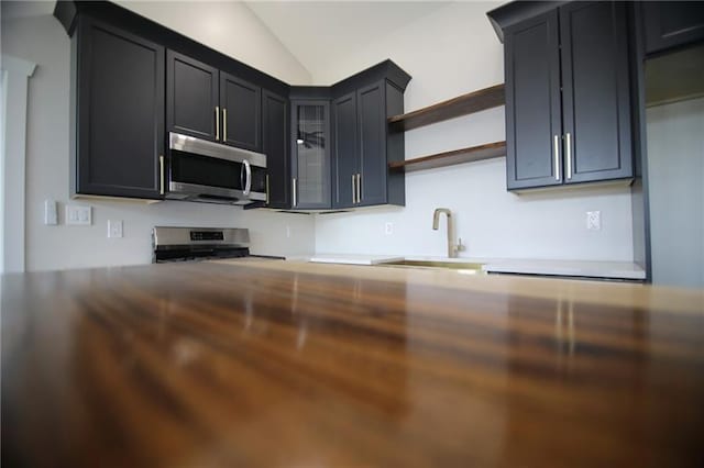 2040 Constitution Blvd, Elizabeth Twp/Boro, PA 15135 - kitchen featuring stainless steel microwave, a sink, range, glass insert cabinets, and dark cabinetry