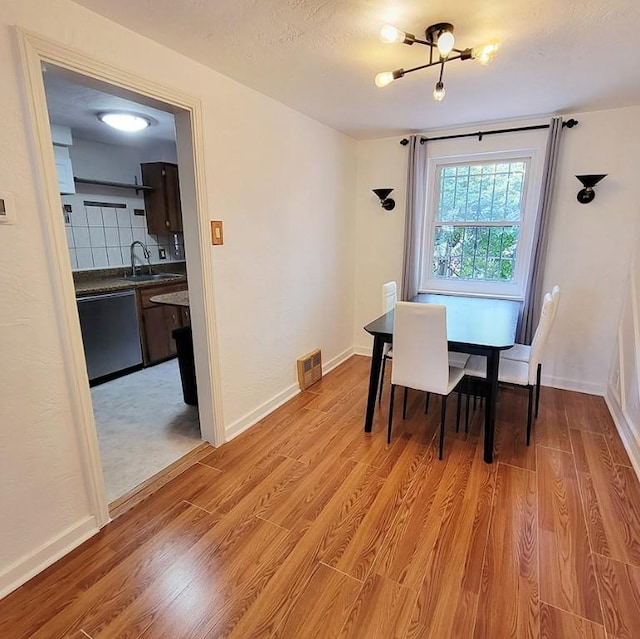 851 Kennebec St, Greenfield, PA 15217 - dining space with light wood finished floors, a chandelier, and baseboards