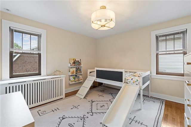 503 6th St, Oakmont, PA 15139 - bedroom featuring radiator, wood finished floors, baseboards, and a chandelier