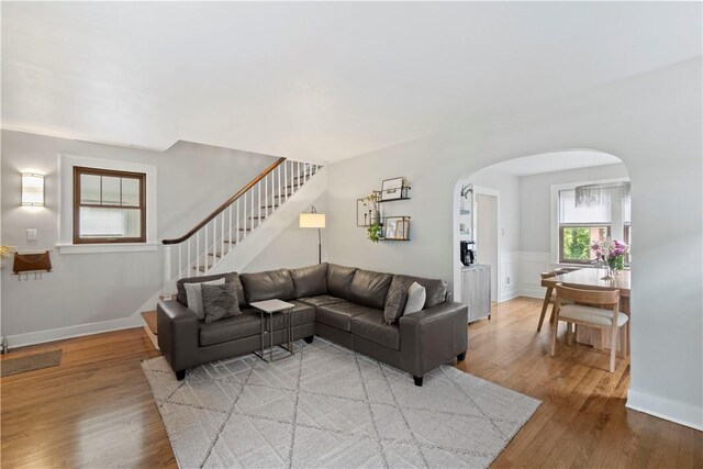 503 6th St, Oakmont, PA 15139 - living room featuring arched walkways, wood finished floors, stairway, and wainscoting