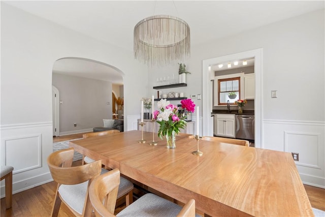 503 6th St, Oakmont, PA 15139 - dining space with arched walkways, wainscoting, wood finished floors, and a decorative wall