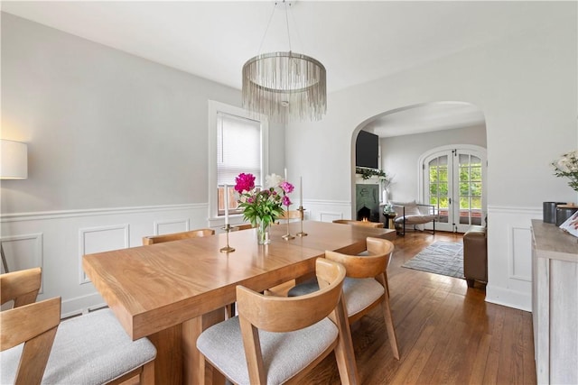503 6th St, Oakmont, PA 15139 - dining room with arched walkways, wainscoting, a decorative wall, hardwood / wood-style floors, and french doors