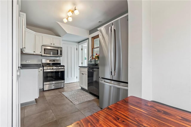 503 6th St, Oakmont, PA 15139 - kitchen featuring stainless steel appliances, dark countertops, white cabinets, and dark tile patterned flooring