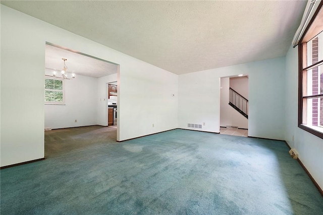662 Huntington Dr, Cranberry Twp, PA 16066 - carpeted empty room with a chandelier, stairs, and a textured ceiling