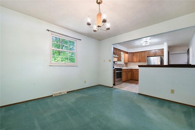 662 Huntington Dr, Cranberry Twp, PA 16066 - kitchen featuring stainless steel appliances, a chandelier, light carpet, brown cabinetry, and decorative light fixtures