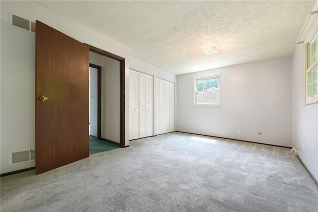 662 Huntington Dr, Cranberry Twp, PA 16066 - unfurnished bedroom featuring two closets, carpet, and a textured ceiling
