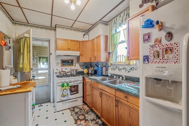306 Meadow Ave, Charleroi Boro, PA 15022 - kitchen featuring white appliances, a sink, under cabinet range hood, dark countertops, and light flooring