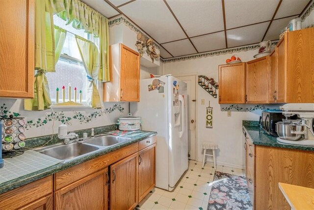 306 Meadow Ave, Charleroi Boro, PA 15022 - kitchen featuring a drop ceiling, light flooring, a sink, black microwave, and brown cabinets