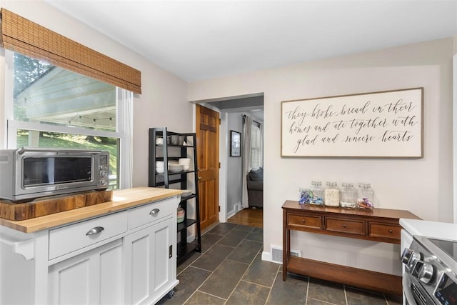 752 Washington, Ross Twp, PA 15229 - kitchen with butcher block countertops, white cabinetry, stainless steel range, and baseboards