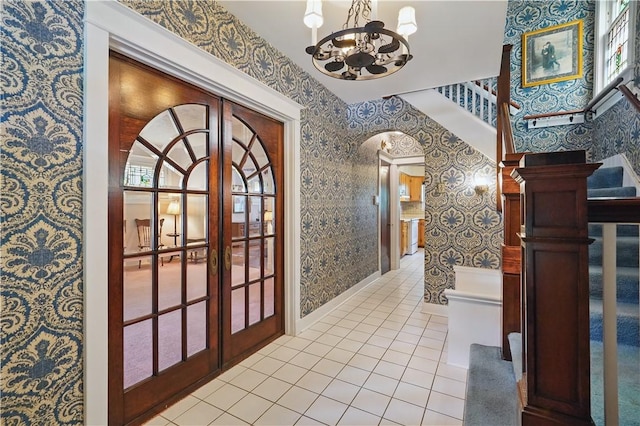 1150 Morningside Ave, Morningside, PA 15206 - hall with wallpapered walls, a chandelier, french doors, light tile patterned flooring, and arched walkways