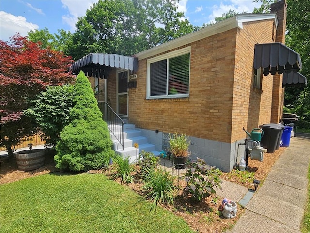 1099 Vine St, Coraopolis, PA 15108 - view of front of property with a chimney, brick siding, a front yard, and crawl space