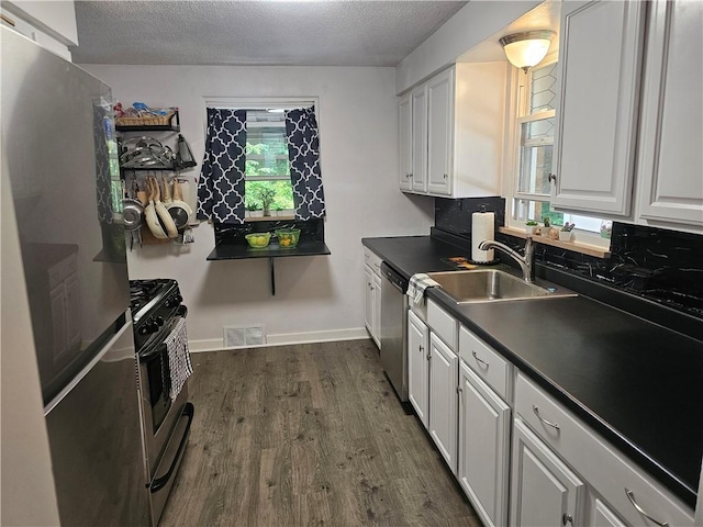 1099 Vine St, Coraopolis, PA 15108 - kitchen featuring appliances with stainless steel finishes, a sink, dark wood finished floors, dark countertops, and a textured ceiling
