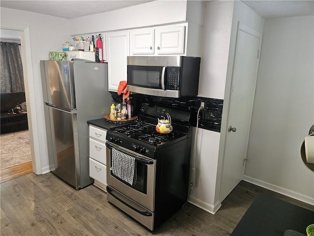 1099 Vine St, Coraopolis, PA 15108 - kitchen featuring appliances with stainless steel finishes, wood finished floors, white cabinetry, baseboards, and dark countertops