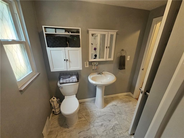 1099 Vine St, Coraopolis, PA 15108 - half bathroom with marble look tiles, toilet, and baseboards