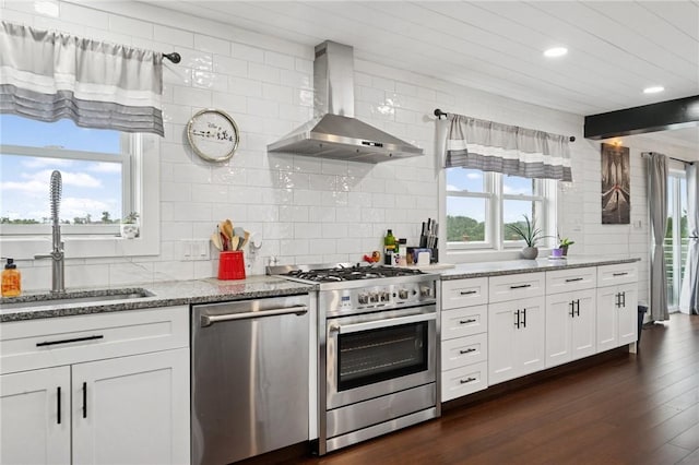 155 Pride Dr, Rostraver, PA 15012 - kitchen featuring stainless steel appliances, wall chimney range hood, backsplash, plenty of natural light, and recessed lighting
