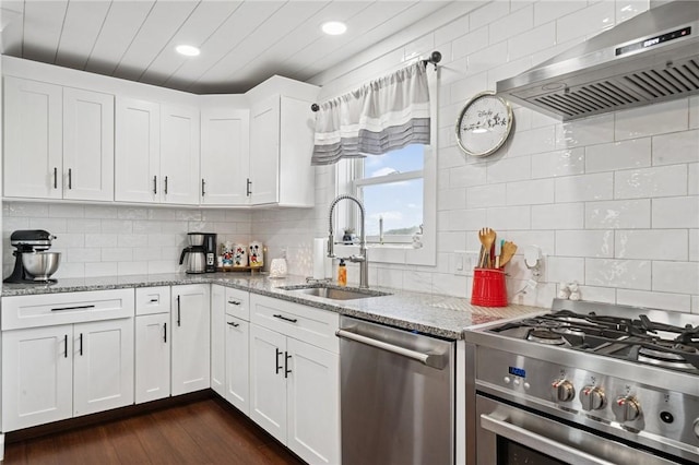 155 Pride Dr, Rostraver, PA 15012 - kitchen with appliances with stainless steel finishes, range hood, backsplash, white cabinets, and recessed lighting