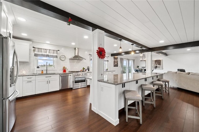 155 Pride Dr, Rostraver, PA 15012 - kitchen featuring appliances with stainless steel finishes, wall chimney exhaust hood, open floor plan, healthy amount of natural light, and recessed lighting