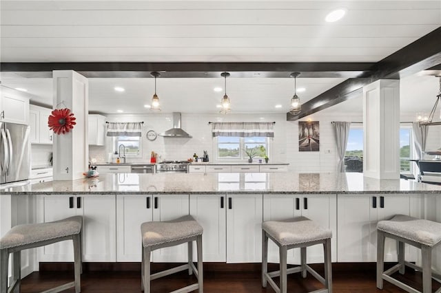 155 Pride Dr, Rostraver, PA 15012 - kitchen featuring wall chimney range hood, decorative backsplash, white cabinetry, dark wood-style floors, and appliances with stainless steel finishes