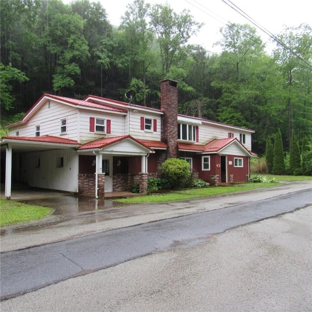 313 Dalton Run Rd, Conemaugh Twp Som, PA 15905 - view of front of home featuring driveway, a chimney, an attached carport, and a forest view