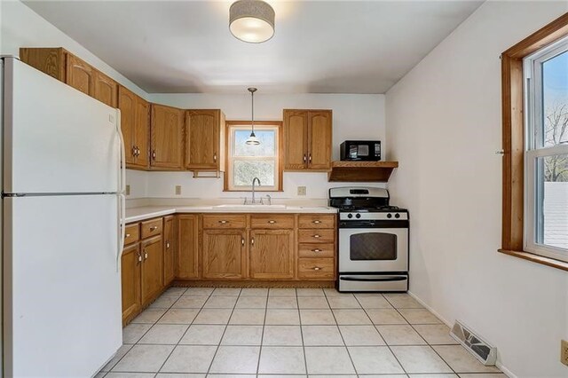 952 Seybertown Rd, Perry Twp, PA 16041 - kitchen featuring freestanding refrigerator, stainless steel gas stove, a sink, light countertops, and black microwave