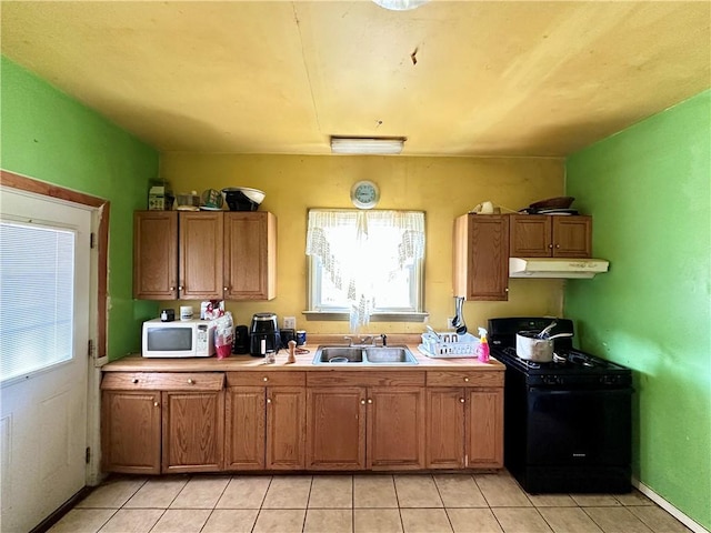 1910 Hamilton St, New Castle/1St, PA 16101 - kitchen featuring gas stove, a sink, under cabinet range hood, white microwave, and light tile patterned floors