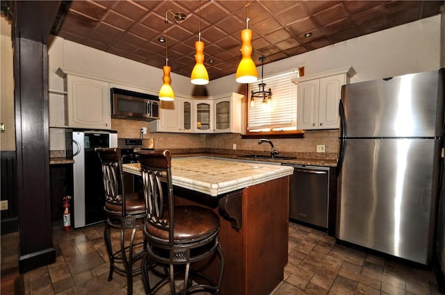 232 Center Ave, Elizabeth Twp/Boro, PA 15037 - kitchen featuring appliances with stainless steel finishes, a sink, a center island, white cabinetry, and decorative backsplash