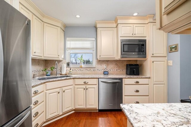 109 Parkview Rd, Ross Twp, PA 15237 - kitchen featuring stainless steel appliances, cream cabinetry, a sink, backsplash, and light stone counters