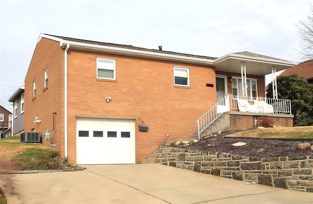 619 Giffin Ave, Canonsburg, PA 15317 - view of side of home with an attached garage, central AC, concrete driveway, brick siding, and covered porch