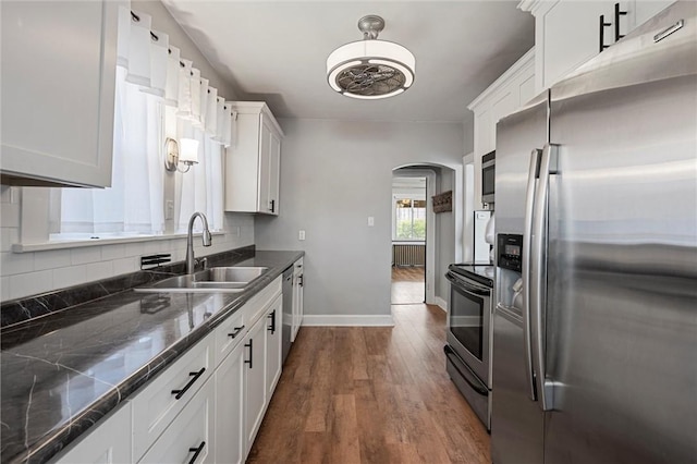 159 Jefferson Ave, Vandergrift Wml, PA 15690 - kitchen with stainless steel appliances, a sink, arched walkways, dark wood finished floors, and baseboards