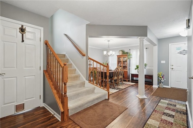 923 Arberdeen Dr, Hempfield Twp Wml, PA 15601 - entrance foyer with ornate columns, dark wood-style floors, a chandelier, and stairs