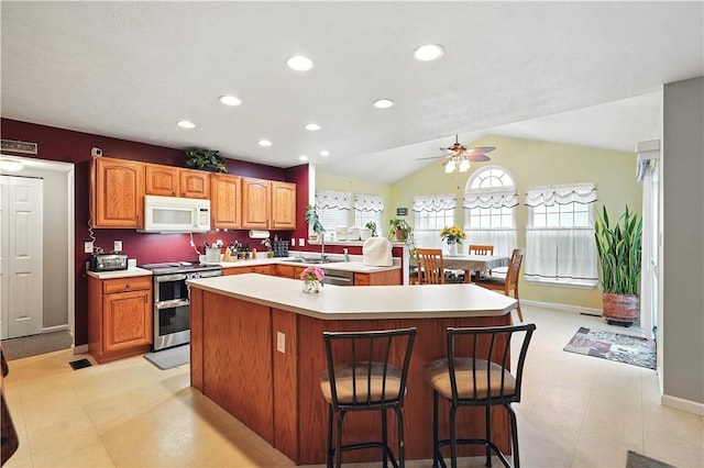 923 Arberdeen Dr, Hempfield Twp Wml, PA 15601 - kitchen with white microwave, electric range, a kitchen island, light countertops, and ceiling fan