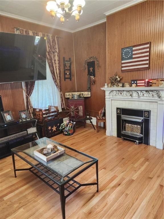 595 N Richhill St, Waynsbrg/Frankln Twp, PA 15370 - living room with a chandelier, ornamental molding, a tiled fireplace, wood finished floors, and wood walls