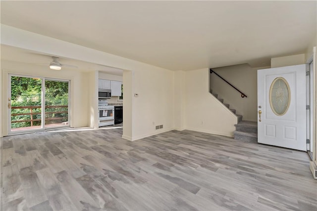 2603 19th St Unit E, Patterson Twp, PA 15010 - unfurnished living room featuring stairs, light wood-type flooring, ceiling fan, and baseboards