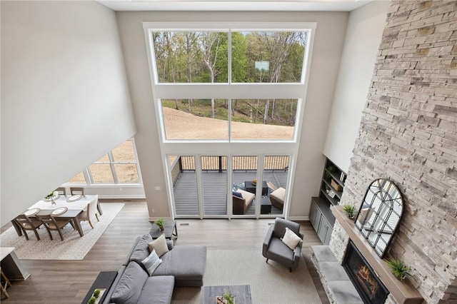 9660 Goehring Rd, Cranberry Twp, PA 16066 - living room with a high ceiling, a stone fireplace, wood finished floors, and baseboards