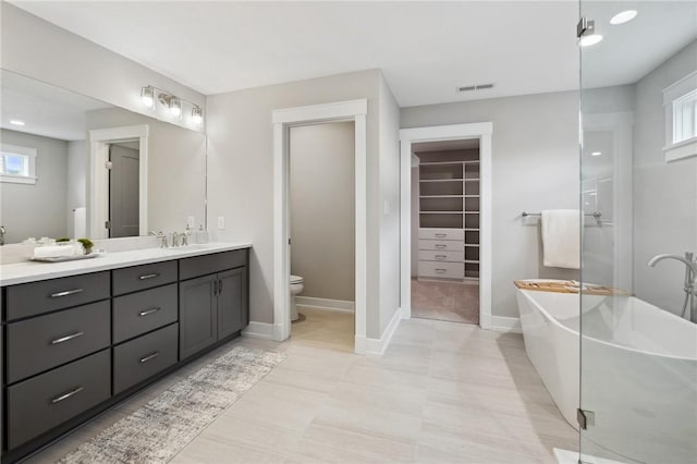 9660 Goehring Rd, Cranberry Twp, PA 16066 - full bathroom featuring double vanity, a spacious closet, a freestanding bath, toilet, and baseboards